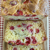 cranberry orange bread sliced on cutting board