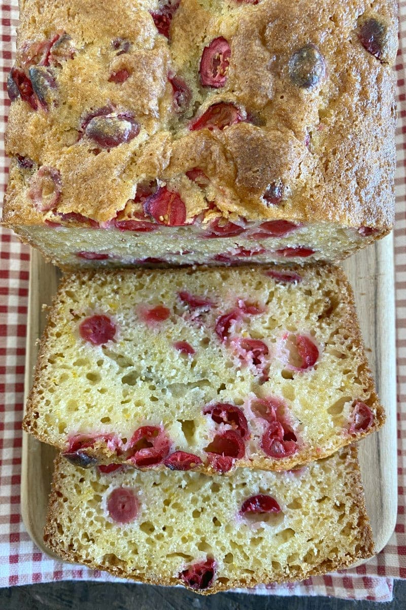 cranberry orange bread sliced on cutting board