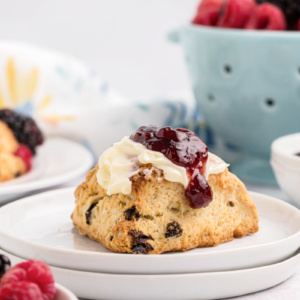 scone on a plate topped with butter and jam