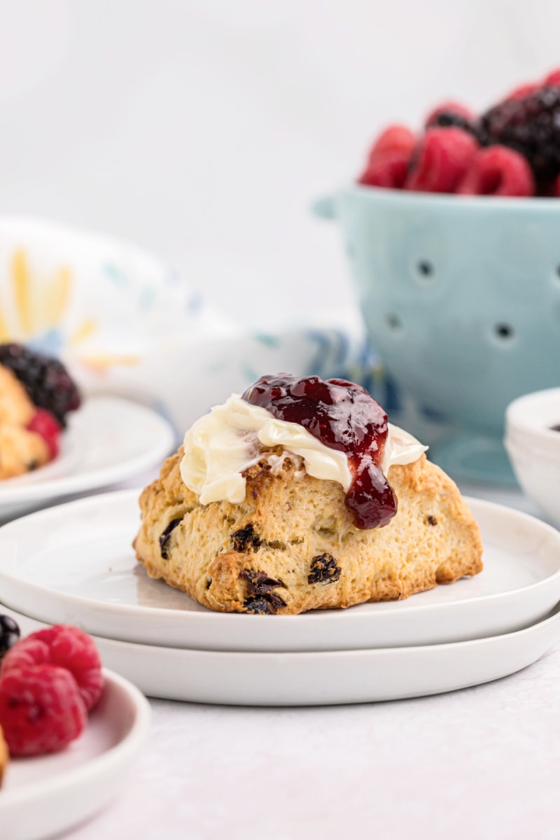 scone on a plate topped with butter and jam