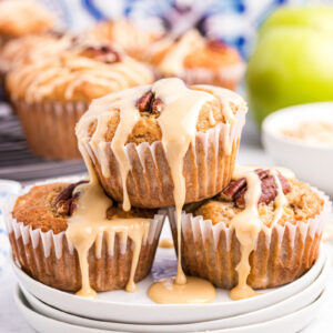 maple drizzled apple muffins stacked on a plate
