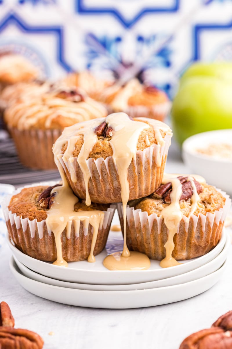 maple drizzled apple muffins stacked on a plate 