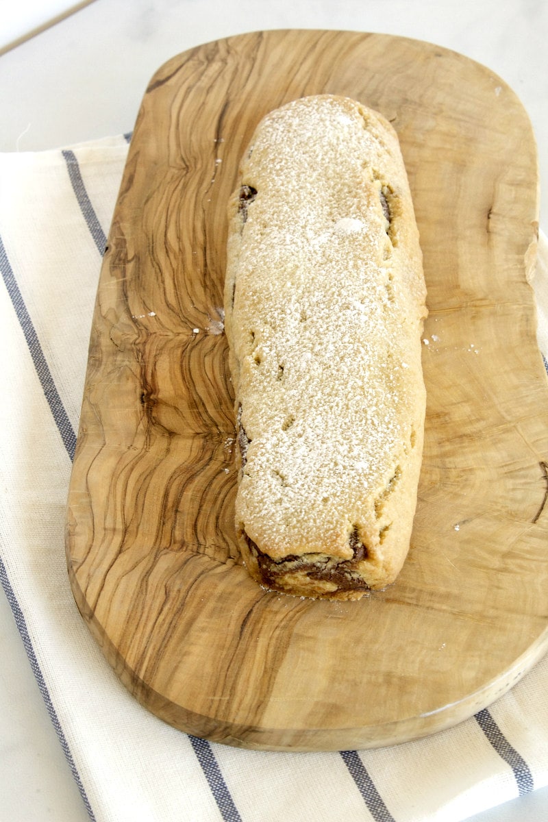 overhead shot of bar of bake and slice cookies sitting on a cutting board with a striped white and blue towel underneath