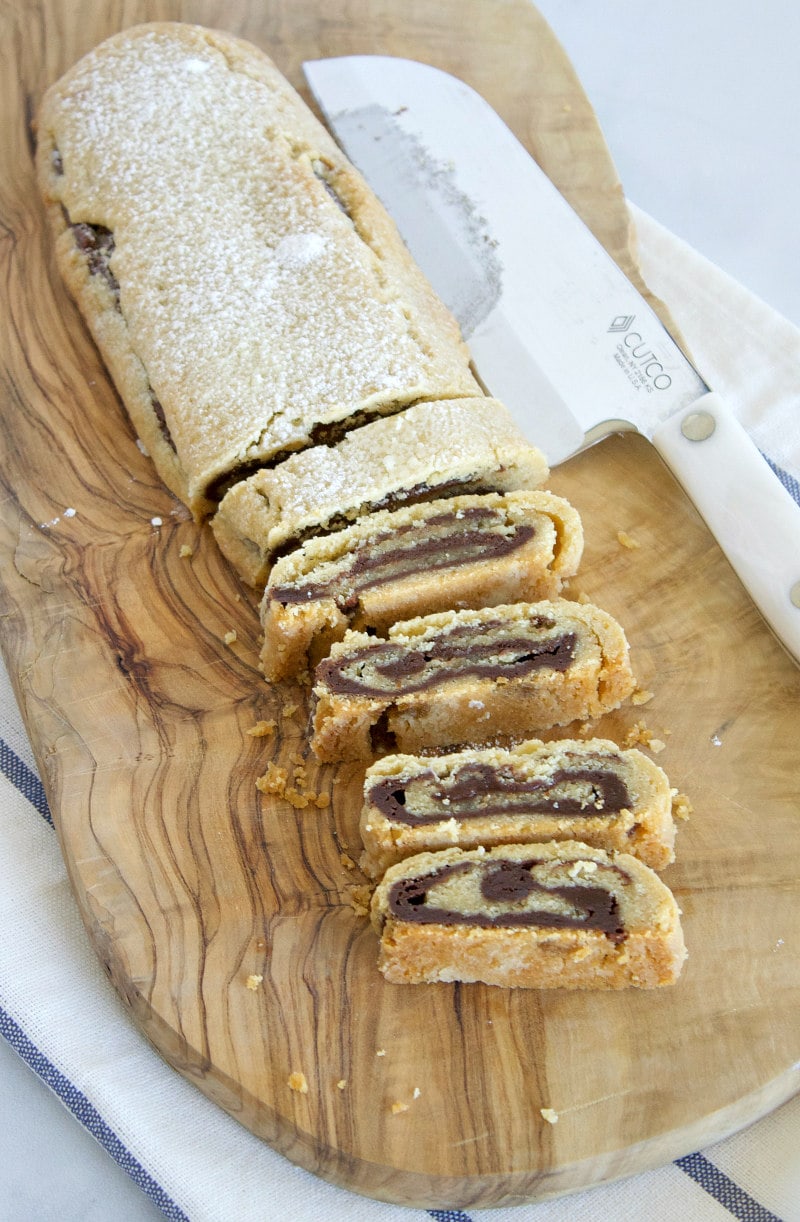 bar of bake and slice chocolate swirl cookies on a cutting board cut into slices