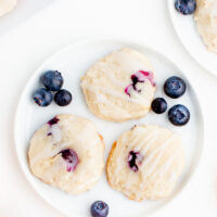 three blueberry cookies on a white plate