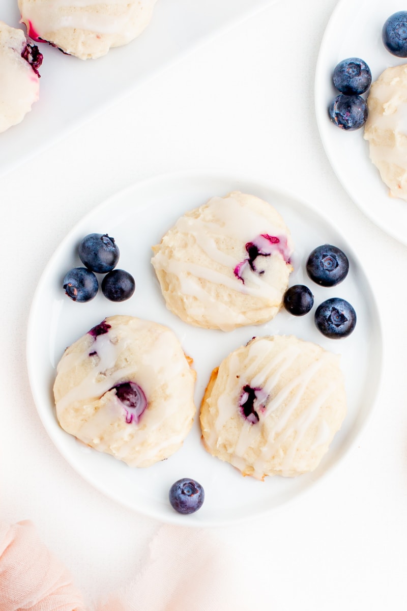 three blueberry cookies on a white plate