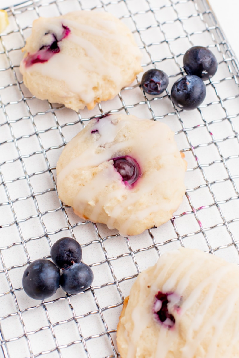 three blueberry cookies on a baking rack