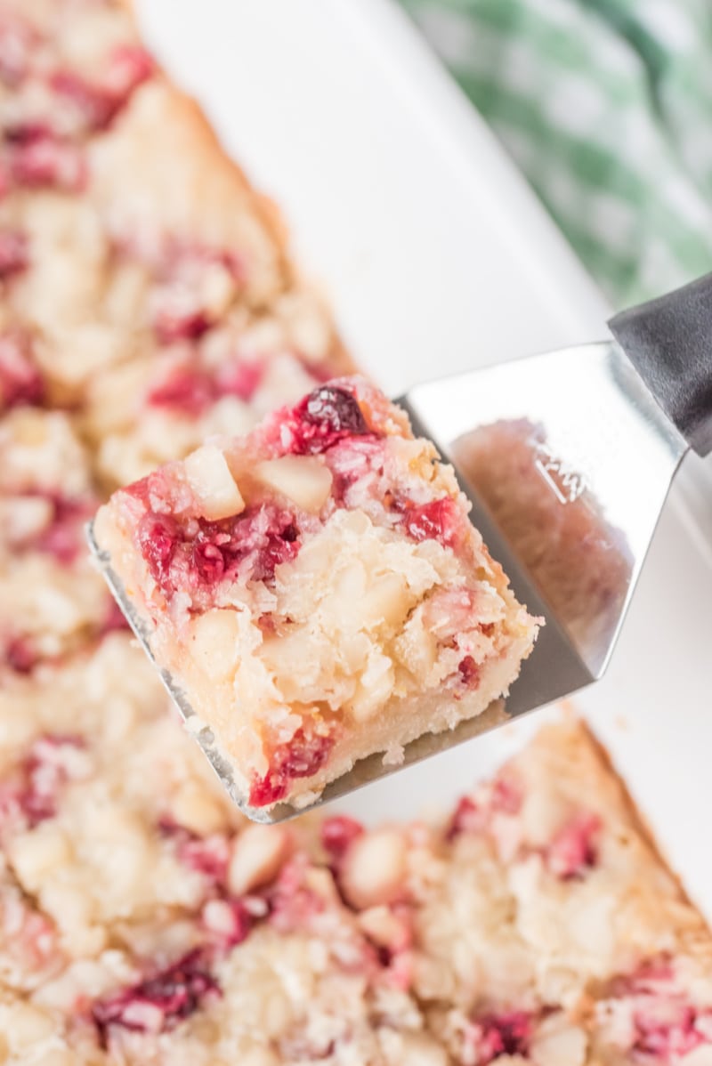 spatula pulling out cranberry macadamia bar