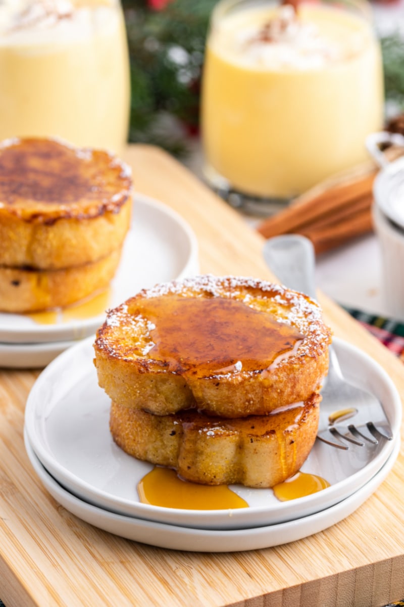 two slices eggnog french toast with syrup on plate