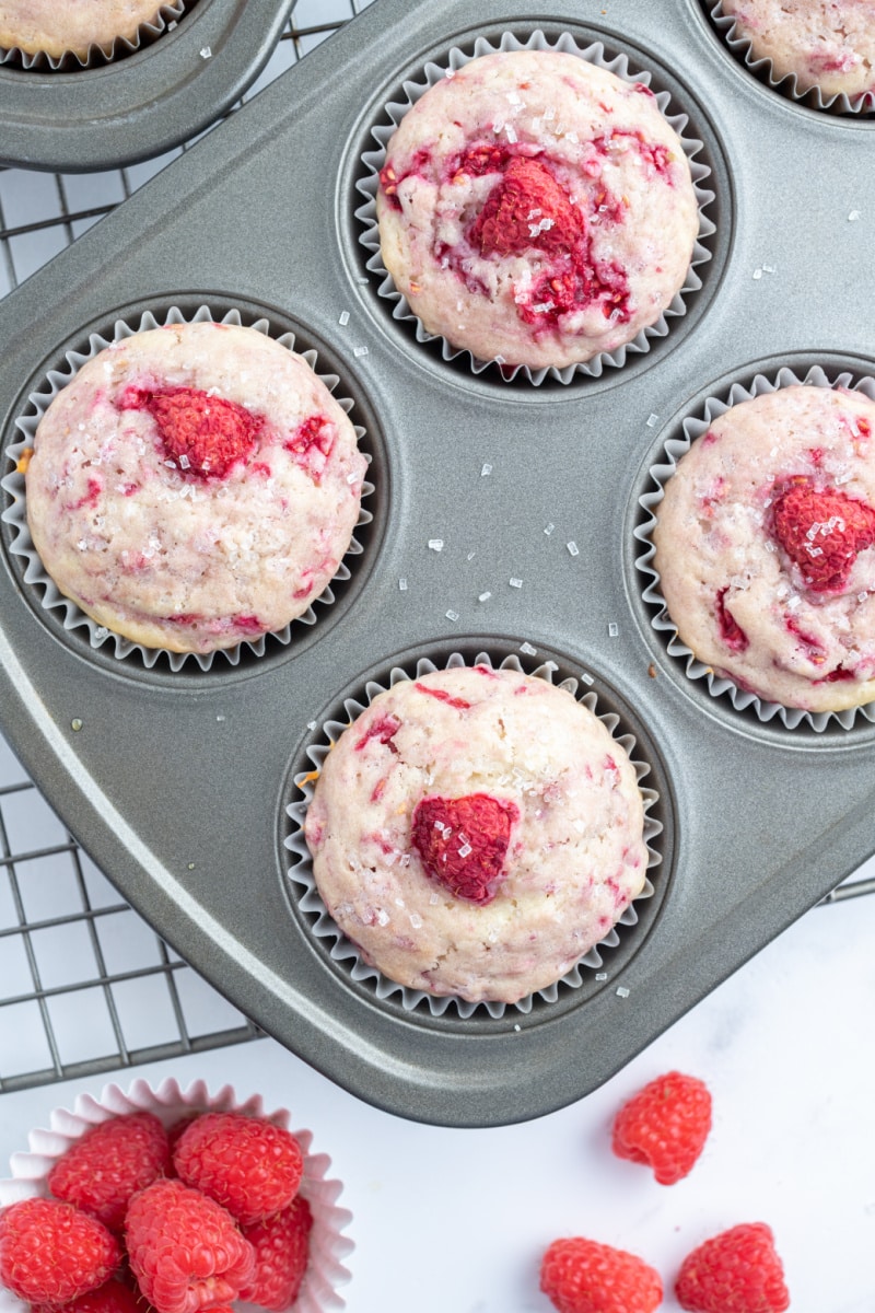 sugar crusted raspberry muffins in a muffin pan