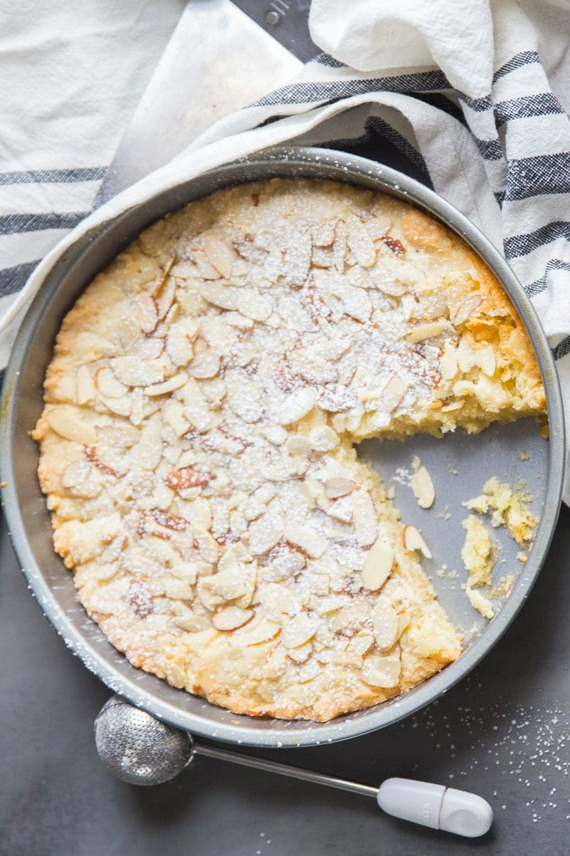 Almond Butter Cake in the baking pan with a slice cut out