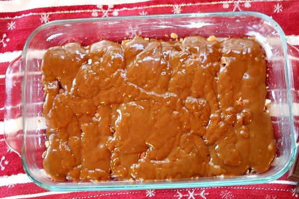 toffee poured over toasted almonds in baking dish to make almond roca
