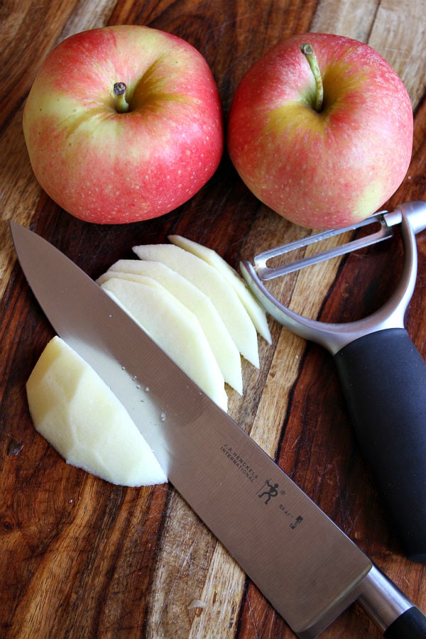 two red apples and one apple peeled and cut with knives