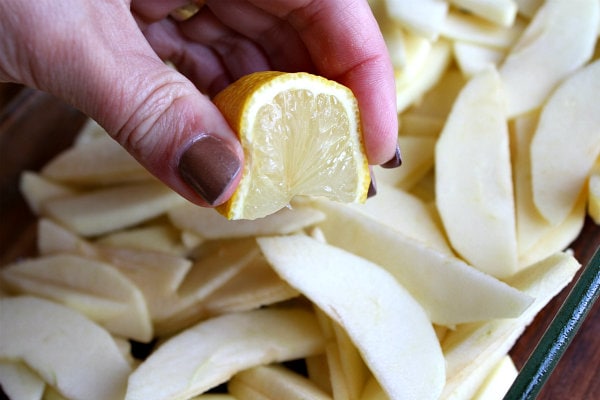 squeezing lemon onto sliced apples