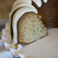 banana bundt cake on a white serving platter. Cake is cut into to see the inside.