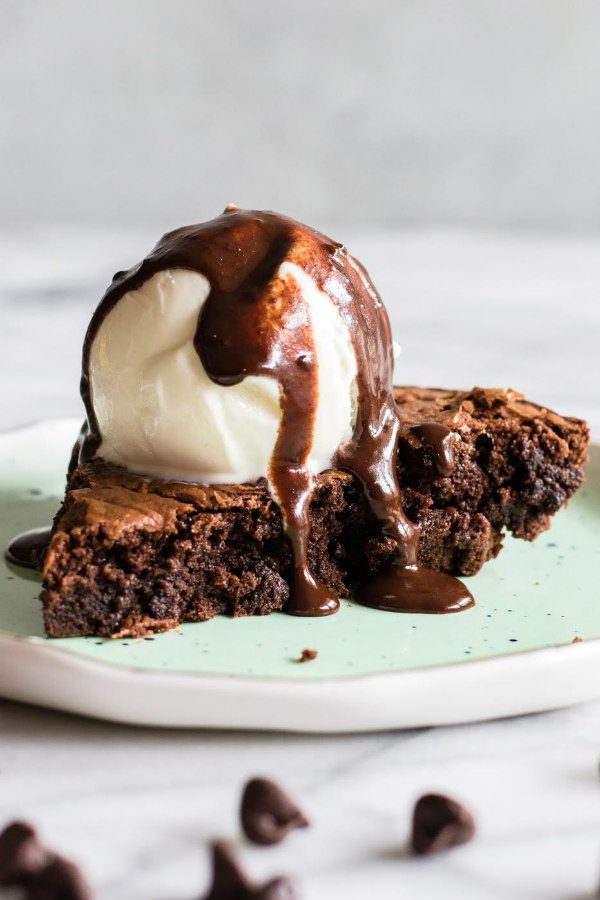 a slice of Brownie Pie a la mode with fudge sauce