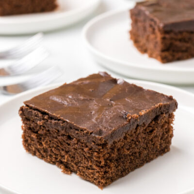 slice of chocolate glazed cake on plate