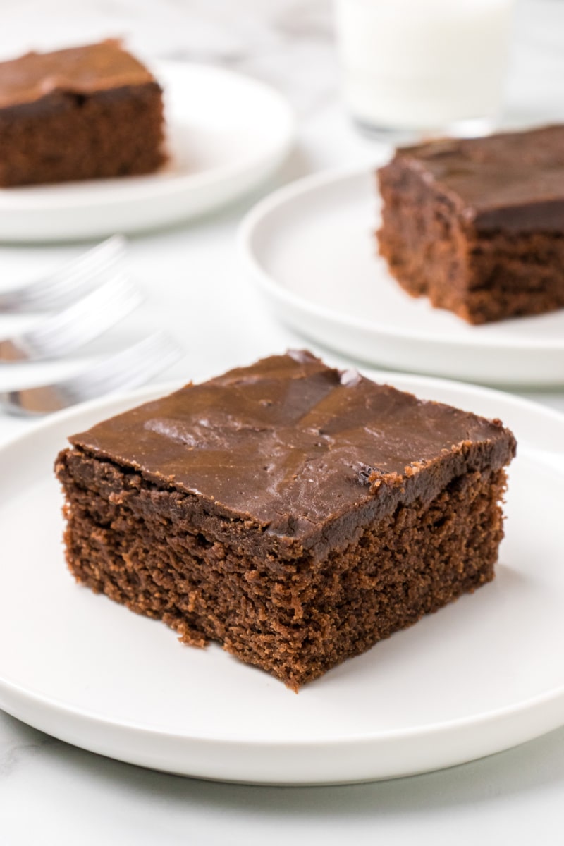 slice of chocolate glazed cake on plate