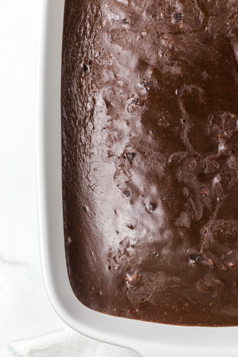peek at half of chocolate glazed cake in pan