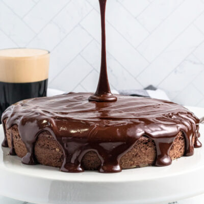 pouring chocolate glaze on top of chocolate cake