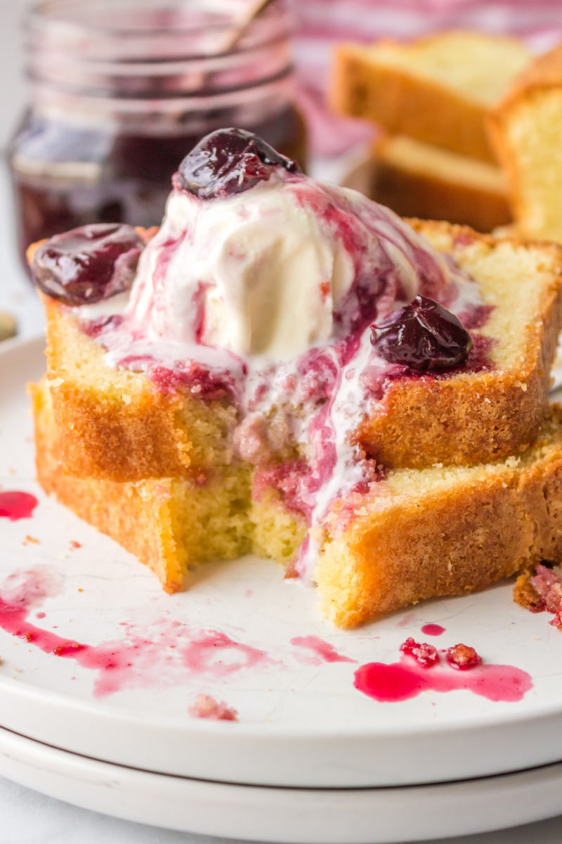 two sliced of pound cake with ice cream and cherry sauce on top