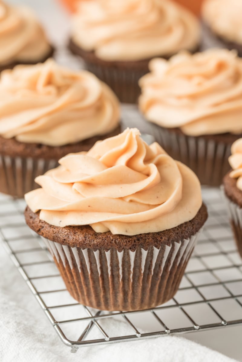 gingerbread cupcakes with pumpkin frosting on rack
