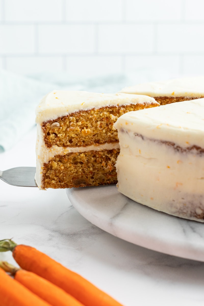 slice being taken out of gingered carrot cake