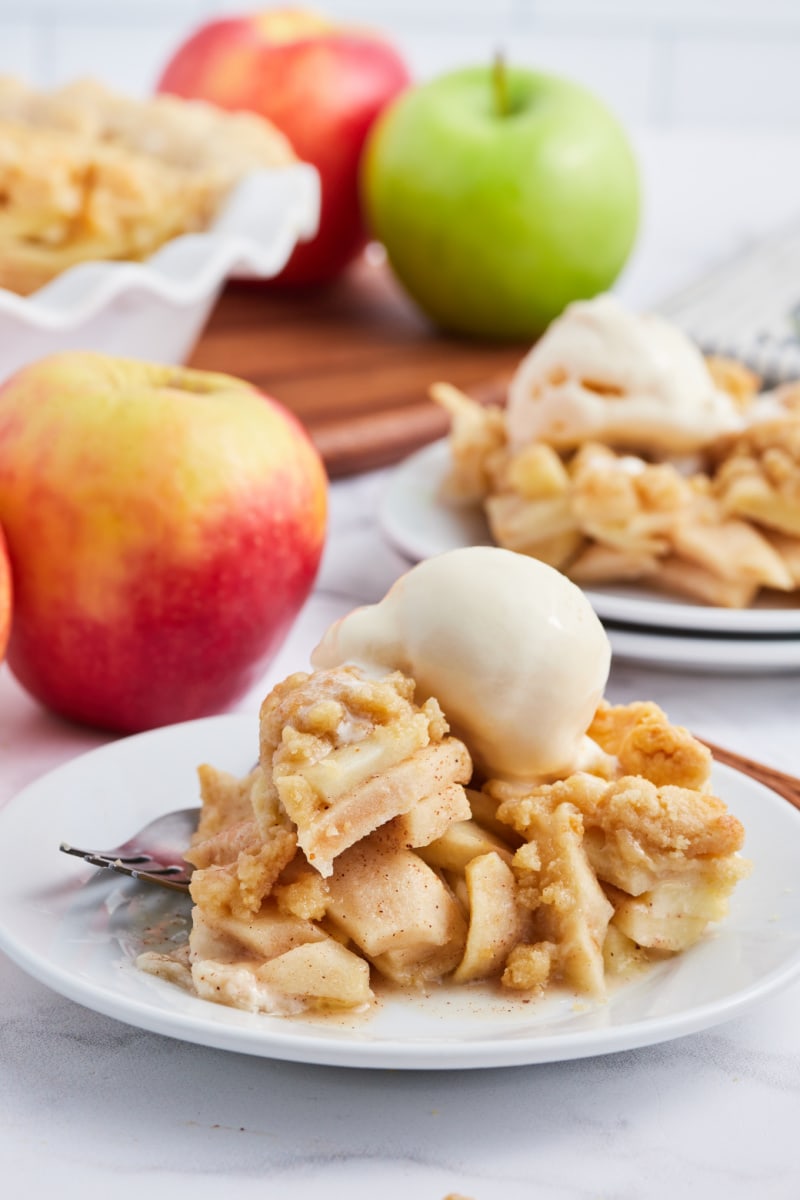 slice of apple pie topped with scoop of vanilla ice cream