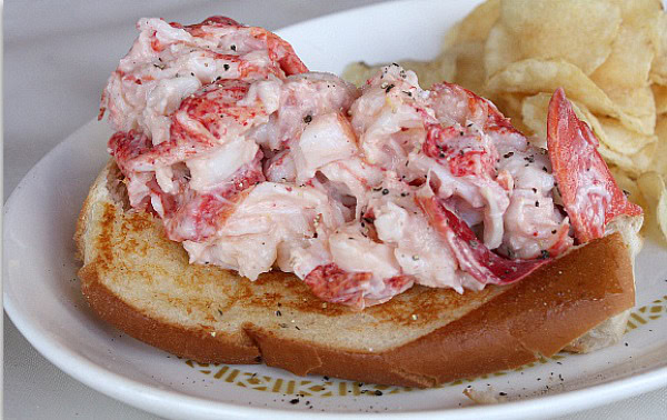 lobster roll on plate with chips