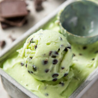 using a scooper to scoop mint chocolate chip ice cream out of the container