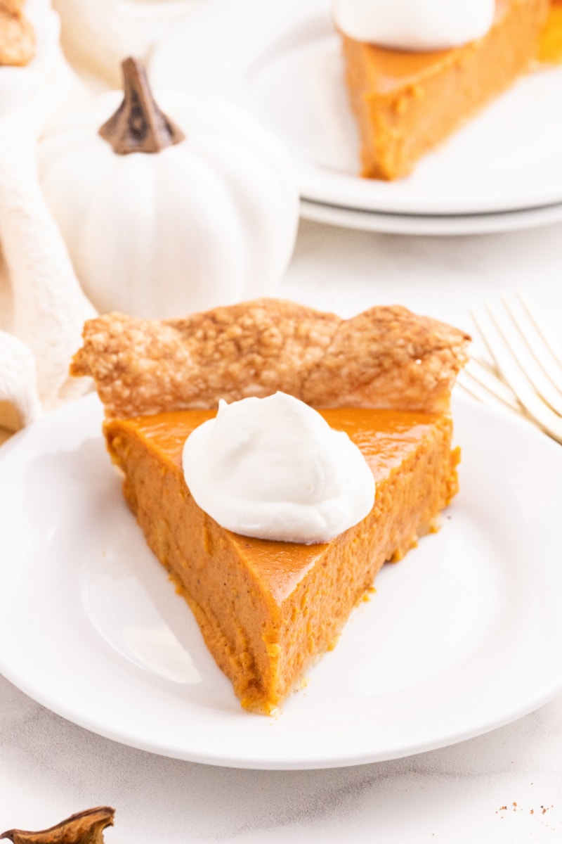 slice of pumpkin pie with whipped cream on plate