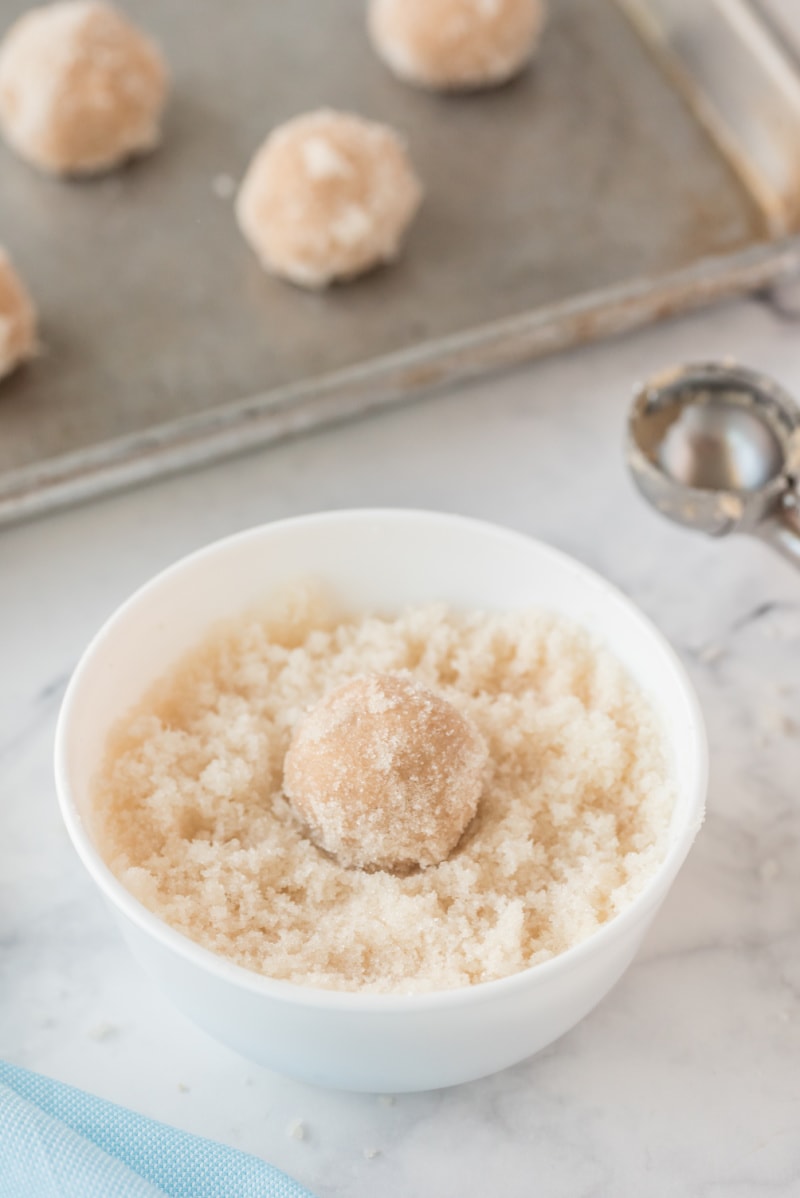 cookie ball of dough rolled in bowl of sugar