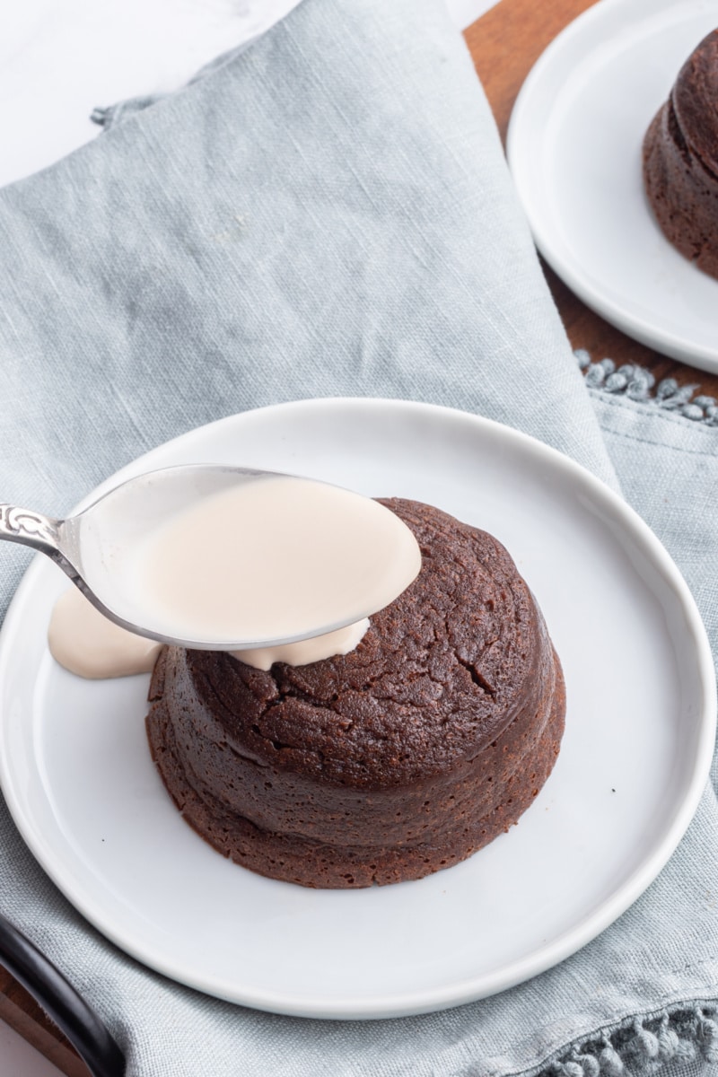 spooning irish cream onto molten chocolate cake