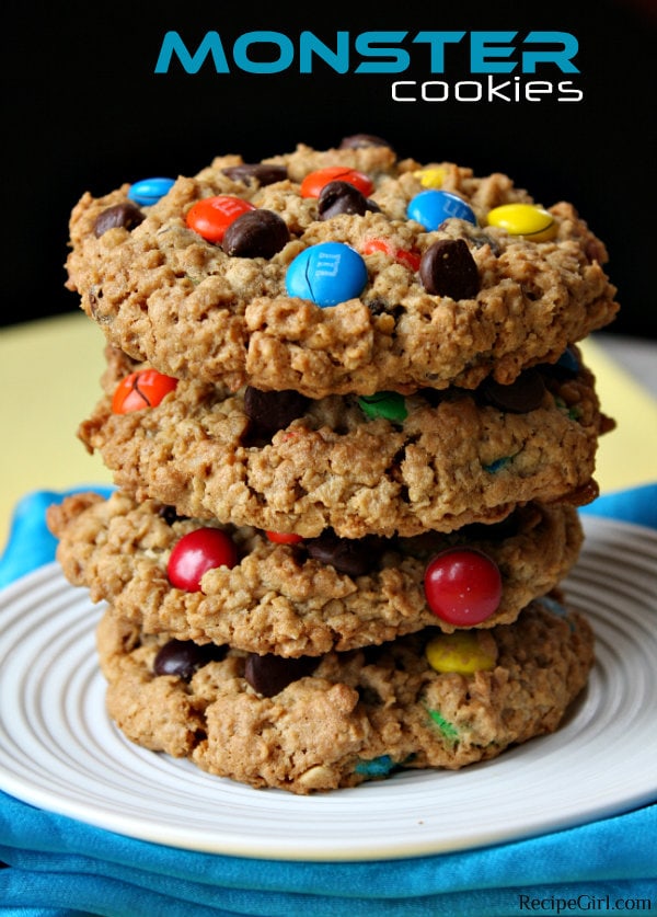 stack of monster cookies on a white plate with a yellow and black background