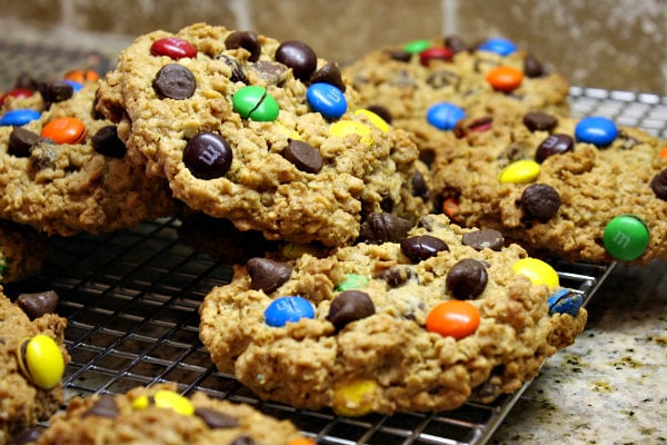 monster cookies piled haphazardly on a cooling rack