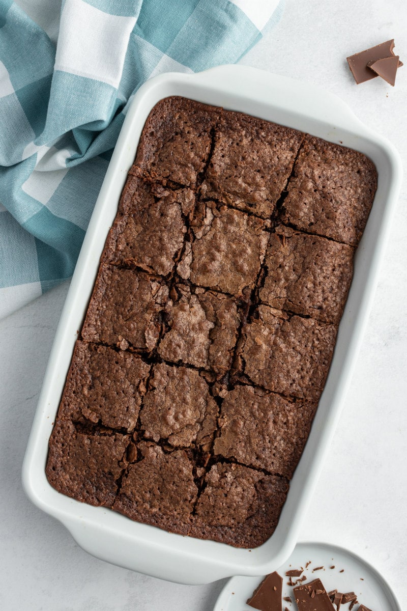 pan of sliced brownies with a blue/white checked napkin in the background