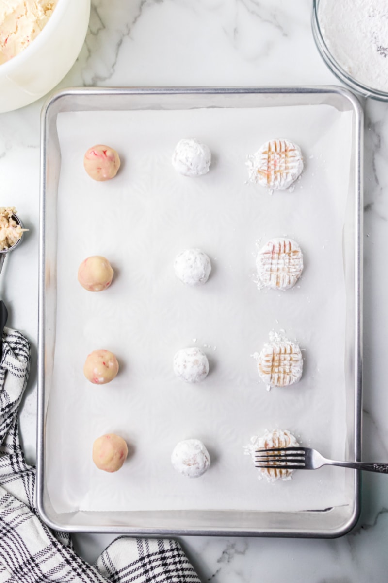 cookie dough on baking sheet showing added sugar and criss cross with fork