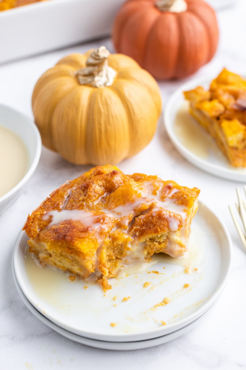 slice of pumpkin bread pudding on plate with bite taken out of it