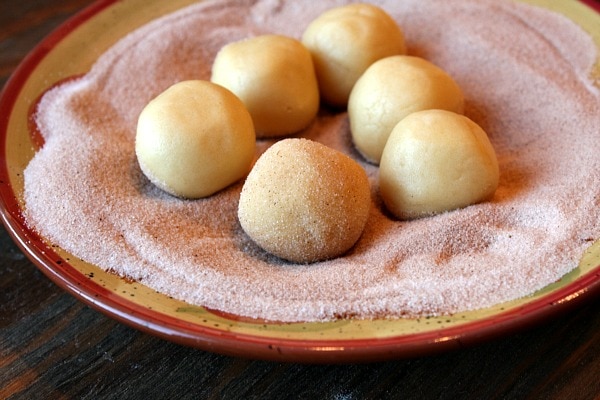cookie dough balls sitting in cinnamon sugar