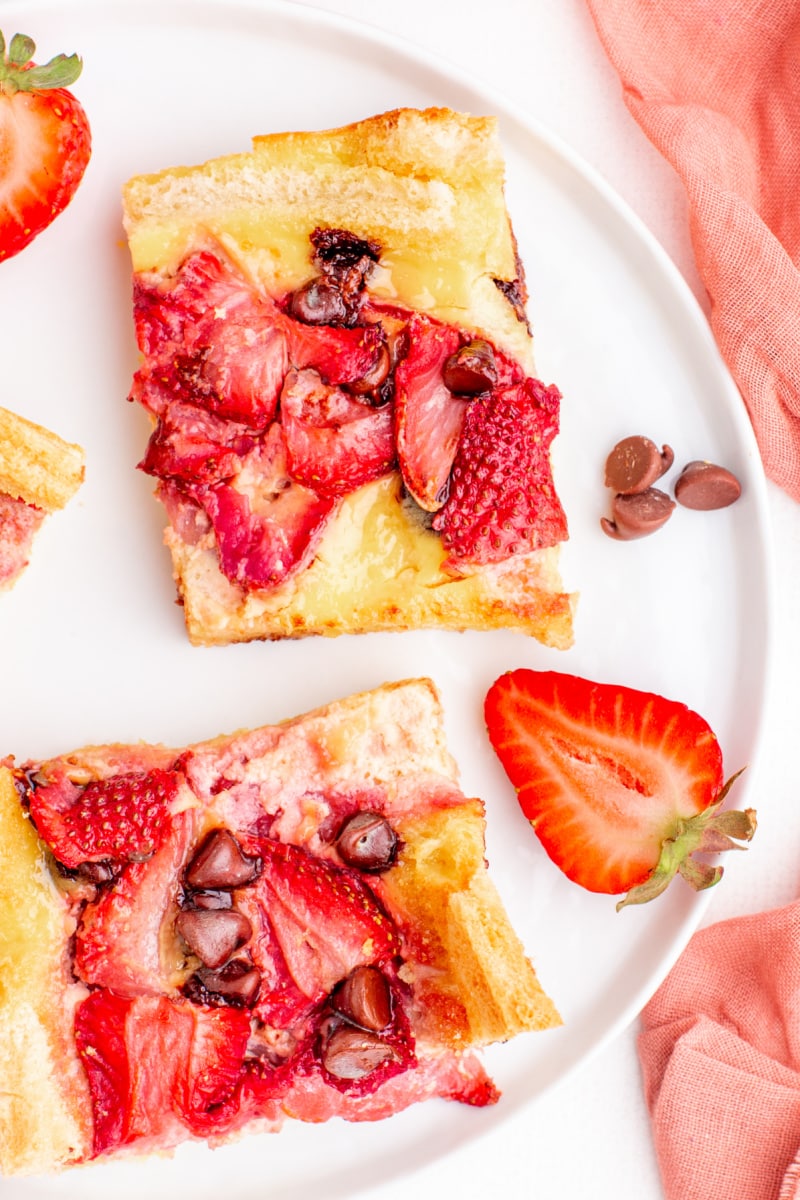 two slices of strawberry chocolate chip bread pudding on a plate