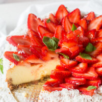 strawberry coconut cheesecake on platter with a slice removed