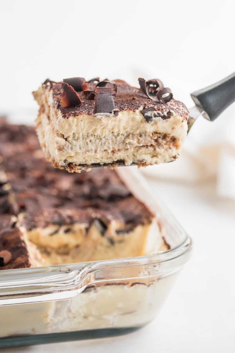 slice of tiramisu being taken out of whole dessert