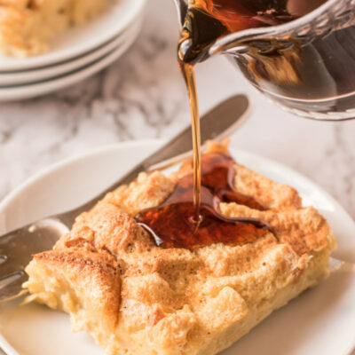 syrup poured over slice of maple custard bread pudding