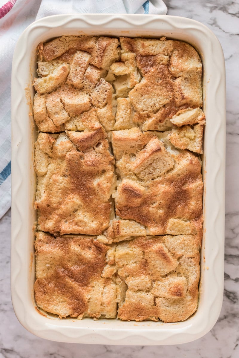 maple custard bread pudding in white casserole dish cut into slices