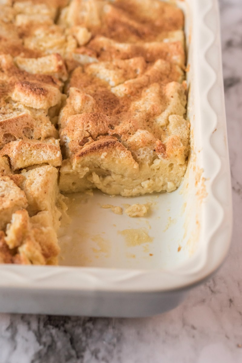 maple custard bread pudding in casserole dish with slice taken out of it