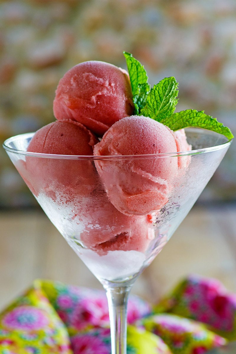 Scoops of Watermelon Sorbet in a martini glass, garnished with fresh mint