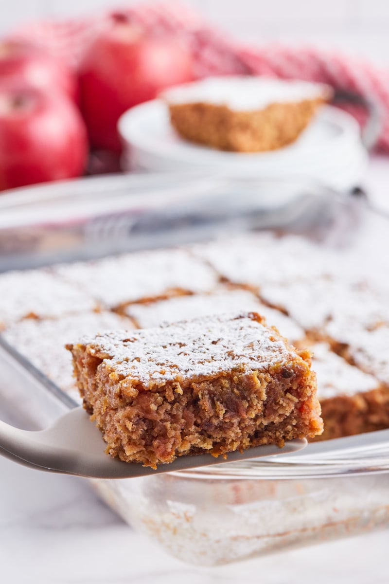 spatula taking piece of apple cake out of pan