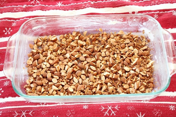 toasted almonds in a baking dish to start the process of making almond roca