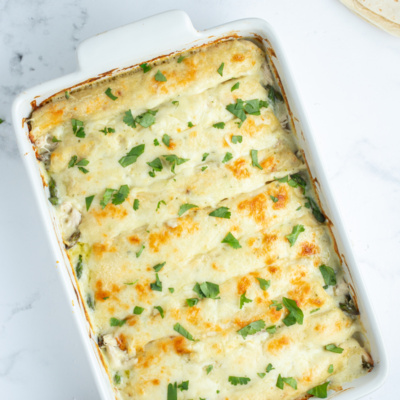 asparagus and chicken enchiladas in a baking pan