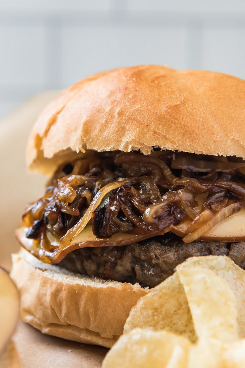 bacon bit burger piled high with sauteed onions, served with potato chips